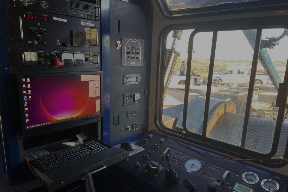 Inside a wireline logging unit cab: acquisition panels, computer, and winch controls